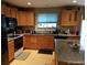 This kitchen boasts wood cabinets, granite countertops and modern appliances, including a black refrigerator and stove at 5256 E 129Th Pl, Thornton, CO 80241