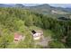 Aerial view of a home nestled in a lush forest with mountain views at 9648 Yegge Rd, Morrison, CO 80465