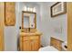 The bathroom has a wood vanity, decorative mirror, and wood-style tile at 9648 Yegge Rd, Morrison, CO 80465