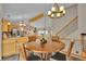 The dining room has a decorative light fixture, wood table, and stairs to the upper level at 9648 Yegge Rd, Morrison, CO 80465