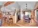 An open-concept dining room has hardwood floors, wood table, and opens to a kitchen with bar stool seating at 9648 Yegge Rd, Morrison, CO 80465
