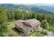 Aerial view of a home with solar panels on the roof surrounded by trees and lush greenery at 9648 Yegge Rd, Morrison, CO 80465