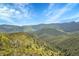 A picturesque view of rolling hills and majestic mountains under a clear sky, showcasing natural beauty at 9648 Yegge Rd, Morrison, CO 80465