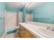 Bright bathroom with dual sinks, tile floors, and tub with shower at 6743 Serena Ave, Castle Pines, CO 80108