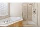 A luxurious bathroom featuring a soaking tub and a separate glass-enclosed shower at 6743 Serena Ave, Castle Pines, CO 80108