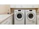 Well-equipped laundry room with washer, dryer, and storage cabinets above sink at 6743 Serena Ave, Castle Pines, CO 80108