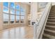Bright living room boasts soaring windows, fireplace, and staircase access to the upper level at 6743 Serena Ave, Castle Pines, CO 80108