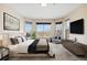 Staged main bedroom featuring a comfortable bed, bay windows, and a seating area at 6743 Serena Ave, Castle Pines, CO 80108