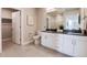 Well-lit bathroom with a double sink vanity, white cabinets, and a glass-enclosed shower at 20 Wilcox St # 410, Castle Rock, CO 80104