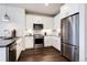 Modern kitchen featuring stainless steel appliances, white cabinets, granite counters, and dark hardwood floors at 20 Wilcox St # 410, Castle Rock, CO 80104