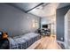 Gray bedroom with a ceiling fan, built-in shelving, and a window providing natural light at 208 Wark Ave, Berthoud, CO 80513