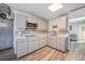 Well-lit kitchen with gray cabinetry, quartz countertops, stainless appliances, and wood-look floors at 208 Wark Ave, Berthoud, CO 80513