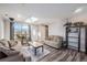 Inviting living room with two sofas, wood-look floors, skylight, and view of the mountains at 208 Wark Ave, Berthoud, CO 80513