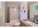 Clean bathroom with tub shower combo, gray tile, and modern vanity at 2945 S Elati St, Englewood, CO 80110