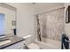 Updated bathroom with tub shower combo, gray tile, and modern vanity at 2945 S Elati St, Englewood, CO 80110