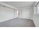 Bedroom featuring neutral carpet, closet with sliding doors, and an attached door at 433 S Vaughn Way, Aurora, CO 80012