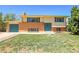 Charming two-story home with brick accents, blue door, and manicured lawn at 433 S Vaughn Way, Aurora, CO 80012