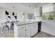 Bright kitchen features white cabinetry, modern appliances, and an adjacent dining area at 433 S Vaughn Way, Aurora, CO 80012