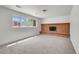 Living room with neutral carpet, large window with natural light, and brick fireplace at 433 S Vaughn Way, Aurora, CO 80012