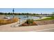 Beautiful waterfront with sidewalks, handrails and flowers near a lake with boats and green trees in the background at 1540 Zenobia St, Denver, CO 80204