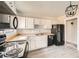 Renovated kitchen with white cabinets and black appliances at 1230 Peoria St, Aurora, CO 80011