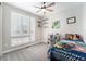 Bright bedroom features a ceiling fan, white window shutters, and playful decor, creating a cheerful and inviting space at 5331 Routt Ct, Arvada, CO 80002