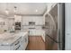 Modern kitchen with stainless steel appliances, white cabinetry, granite countertops, and an island with a sink at 5331 Routt Ct, Arvada, CO 80002