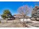 Two-story home with a stone facade and attached three-car garage surrounded by large trees and ranch-style fencing at 12925 Sierra Cir, Parker, CO 80138