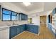 Modern kitchen with blue cabinetry, stainless steel appliances, and a large sink at 12925 Sierra Cir, Parker, CO 80138