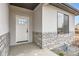 Up-close view of a front entry door with stone veneer siding, showcasing the modern exterior details at 15 S Gray St, Lakewood, CO 80226