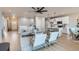 Open-concept living room flowing into a white kitchen with an island and barstool seating at 15 S Gray St, Lakewood, CO 80226