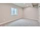 An empty carpeted room with a large window, offering potential for various uses at 15 S Gray St, Lakewood, CO 80226