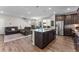 Open kitchen features granite countertops, stainless steel appliances, and wood floors at 6129 Dayton St, Denver, CO 80238