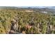 Scenic aerial view of a home nestled among trees, with distant mountains in the background, providing a serene and private setting at 31219 Florence Rd, Conifer, CO 80433