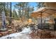 Charming backyard features a seating area, a spa, water feature, and mature trees at 31219 Florence Rd, Conifer, CO 80433