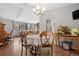 Open-concept dining room boasts hardwood floors, a chandelier, and is adjacent to a living area with large windows at 31219 Florence Rd, Conifer, CO 80433