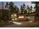 Inviting two-story home featuring a charming front porch and attached garage nestled among tall pine trees at 31219 Florence Rd, Conifer, CO 80433