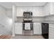 Modern kitchen features stainless steel appliances, granite countertops, white cabinets, and tile floors at 31219 Florence Rd, Conifer, CO 80433