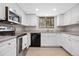 Bright kitchen featuring white cabinets, stainless steel appliances, granite countertops, and a window view at 31219 Florence Rd, Conifer, CO 80433
