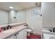 Bathroom with a large mirror, large vanity, and red floors at 4090 S Tamarac Dr, Denver, CO 80237