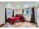 Cozy bedroom with tile flooring, natural light, and red bedding at 4090 S Tamarac Dr, Denver, CO 80237