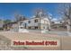 Charming home with white exterior, complemented by brick accents and a spacious driveway at 4090 S Tamarac Dr, Denver, CO 80237