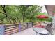 Deck featuring a partial view of the treed landscaping and bright red patio umbrella at 6503 Big Horn Trl, Littleton, CO 80125
