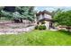 Beautiful backyard featuring a retaining wall, lush lawn, patio area, and professional landscaping at 6503 Big Horn Trl, Littleton, CO 80125