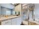 Bathroom with stylish vanity, framed mirror, and walk-in tiled shower at 6503 Big Horn Trl, Littleton, CO 80125