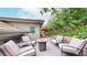 An outdoor deck with ample seating featuring a modern fire pit with mature trees and shade from the sun at 6503 Big Horn Trl, Littleton, CO 80125