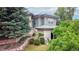 Two-story home with light blue siding and well-maintained landscaping. Rock retaining wall with lush green grass at 6503 Big Horn Trl, Littleton, CO 80125