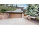 Two-story home featuring a neutral exterior and a spacious garage with a stone retaining wall and well-maintained landscaping at 6503 Big Horn Trl, Littleton, CO 80125