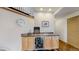 A well-appointed wet bar with custom cabinets, granite countertops, stainless steel appliances, and unique tile flooring at 6503 Big Horn Trl, Littleton, CO 80125