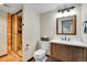 Bathroom with a modern walk-in shower with tiled walls, wooden vanity, and well-lit mirror at 27100 Molly Dr, Conifer, CO 80433
